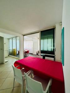 une salle à manger avec une table et des chaises rouges dans l'établissement Chambre d'Hôtes Coconut Marina du Gosier, au Gosier