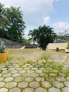une terrasse en pierre avec gazon au sol dans l'établissement Chambre d'Hôtes Coconut Marina du Gosier, au Gosier