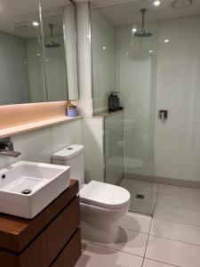 a bathroom with a toilet and a sink and a shower at Urban Eden in South Yarra in Melbourne