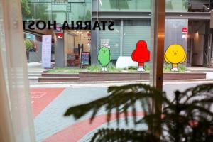 uma janela de uma loja com três pássaros pintados nela em Starria Hostel foreign guest only em Seul