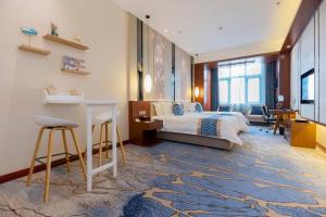 a bedroom with a bed and a desk in a room at YunRay Hotel Shijiazhuang in Shijiazhuang