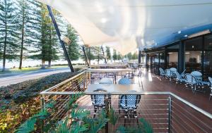 a patio with chairs and tables on a building at Pippi's at the Point in Warners Bay