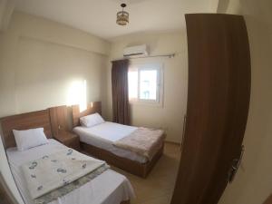 een hotelkamer met 2 bedden en een raam bij Remas resort in El Alamein