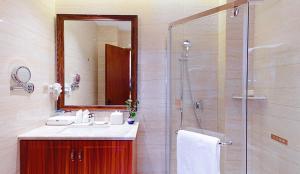 a bathroom with a shower and a sink and a mirror at YunRay Hotel Shijiazhuang in Shijiazhuang