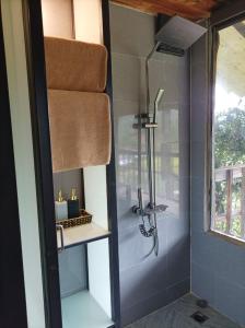 La salle de bains est pourvue d'une douche avec une porte en verre. dans l'établissement Mu Cang Chai Eco Lodge, à Nam San