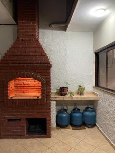 a brick oven with three blue pots in a room at Excelente Quarto Próximo Ao Metrô in Sao Paulo