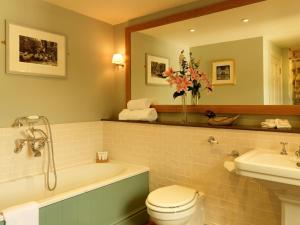 a bathroom with a tub and a toilet and a sink at Devonshire Arms at Pilsley - Chatsworth in Baslow