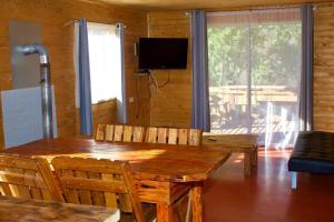 - une salle à manger avec une table et des chaises en bois dans l'établissement Cabañas oasis, radal 7 tazas, à El Torreón