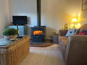 a living room with a wood stove in a living room at Windspray Cottage in Port Albert