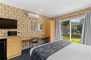 um quarto de hotel com uma cama e uma televisão em Great Divide Motor Inn em Toowoomba