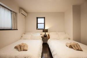 duas camas sentadas uma ao lado da outra num quarto em KS west Waseda 2F em Tóquio