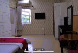 HOTEL HOA HUỲNH في مدينة هوشي منه: غرفة نوم بها سرير وطاولة ونافذة