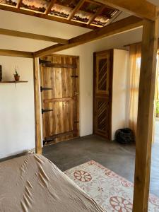 a room with a bed and a wooden door at Gypsea Cabana in Arugam Bay