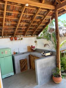 a kitchen under a wooden roof with a stove at Gypsea Cabana in Arugam Bay