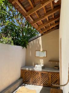 a bathroom with a sink under a wooden ceiling at Gypsea Cabana in Arugam Bay