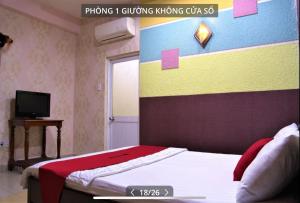 a bedroom with a bed with a colorful wall at HOTEL HOA HUỲNH in Ho Chi Minh City
