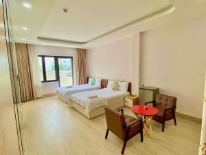 a bedroom with a bed and a table and chairs at HOTEL HOA HUỲNH in Ho Chi Minh City