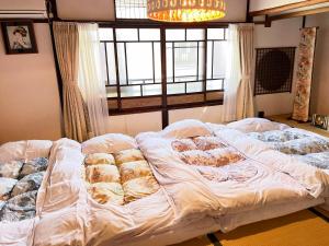 Postel nebo postele na pokoji v ubytování Kyounoyado HANA Nishijin - Kimono no Yado