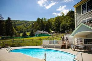 a swimming pool in a yard next to a house at Mountain View Suite on Jiminy Peak Ski On Off -New in Hancock