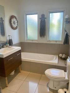ein Badezimmer mit einer Badewanne, einem WC und einem Waschbecken in der Unterkunft Red Rocks Beach Retreat Free Wifi and Foxtel in Cowes