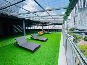 فندق سيتي سنترال في كوالالمبور: مبنى به عشب أخضر وكراسي على شرفة