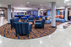 un vestíbulo con sillas y mesas y un bar en Courtyard by Marriott Montgomery Prattville, en Prattville