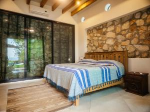 a bedroom with a bed and a stone wall at Casa de la Luna in Puerto Escondido