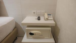 a bed room with a phone and a phone at The Win Hotel Surabaya in Surabaya