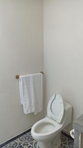 ein Badezimmer mit einem weißen WC und Handtüchern in der Unterkunft Casa Centro San Miguel de Allende in San Miguel de Allende