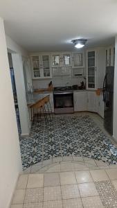 eine Küche mit weißen Schränken und Fliesenboden in der Unterkunft Casa Centro San Miguel de Allende in San Miguel de Allende