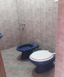 uma casa de banho com um WC azul e um bidé azul em Hostal El Farolito em Humahuaca