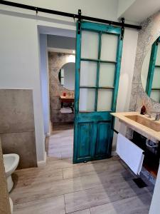 een badkamer met een groene deur en een wastafel bij Lechuza Alvear in San Antonio de Areco