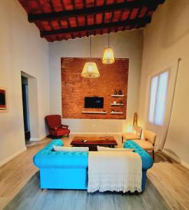 een woonkamer met blauwe meubels en een bakstenen muur bij Lechuza Alvear in San Antonio de Areco