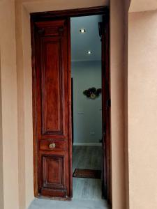 a wooden door in a hallway with a mirror at Lechuza Alvear in San Antonio de Areco