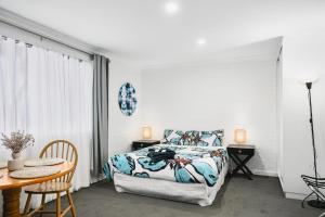 a bedroom with a bed and a desk and a table at Malibu Apartments - Perth in Perth