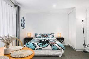 a bedroom with a bed and two tables at Malibu Apartments - Perth in Perth