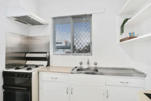 a kitchen with a stove and a sink at Malibu Apartments - Perth in Perth