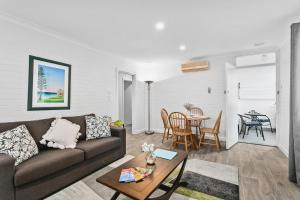 uma sala de estar com um sofá e uma mesa em Malibu Apartments - Perth em Perth