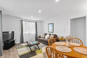 een woonkamer met een bank en een tafel bij Malibu Apartments - Perth in Perth