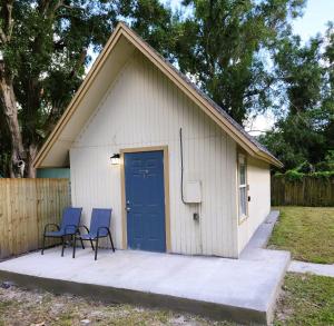 uma garagem com duas cadeiras e uma porta azul em Cozy Cottage em Tampa