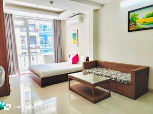 a room with a bed and a couch and a table at Q.MIN apartment in Nha Trang