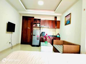 a living room with a kitchen with a refrigerator at Q.MIN apartment in Nha Trang