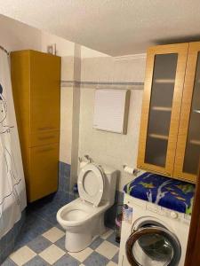 łazienka z toaletą i pralką w obiekcie Dellmar Apartment w mieście Perea