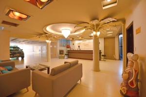 a living room with couches and palm trees in it at Holiday Hotel in Hai Phong
