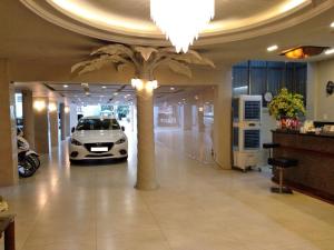 a car parked in a garage with a palm tree at Holiday Hotel in Hai Phong