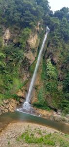 una cascata sul fianco di una montagna con un fiume di Green Hills Homestay 