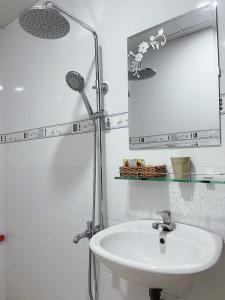 a white bathroom with a sink and a mirror at Thiên Phát Hotel - SECC in Ho Chi Minh City