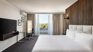 a hotel room with a bed and a television at Holiday Inn Warwick Farm by IHG in Warwick Farm