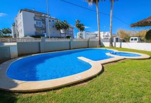 a swimming pool in the yard of a house at Apartamento con terraza y acceso directo a piscina in Denia