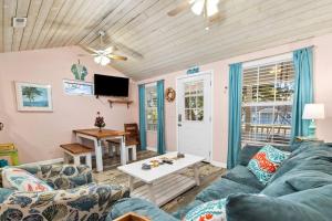 a living room with a couch and a table at Beautiful Centrally Located Beach House w King Bed, Private Hot tub, Yard, Deck & BBQ in Myrtle Beach
